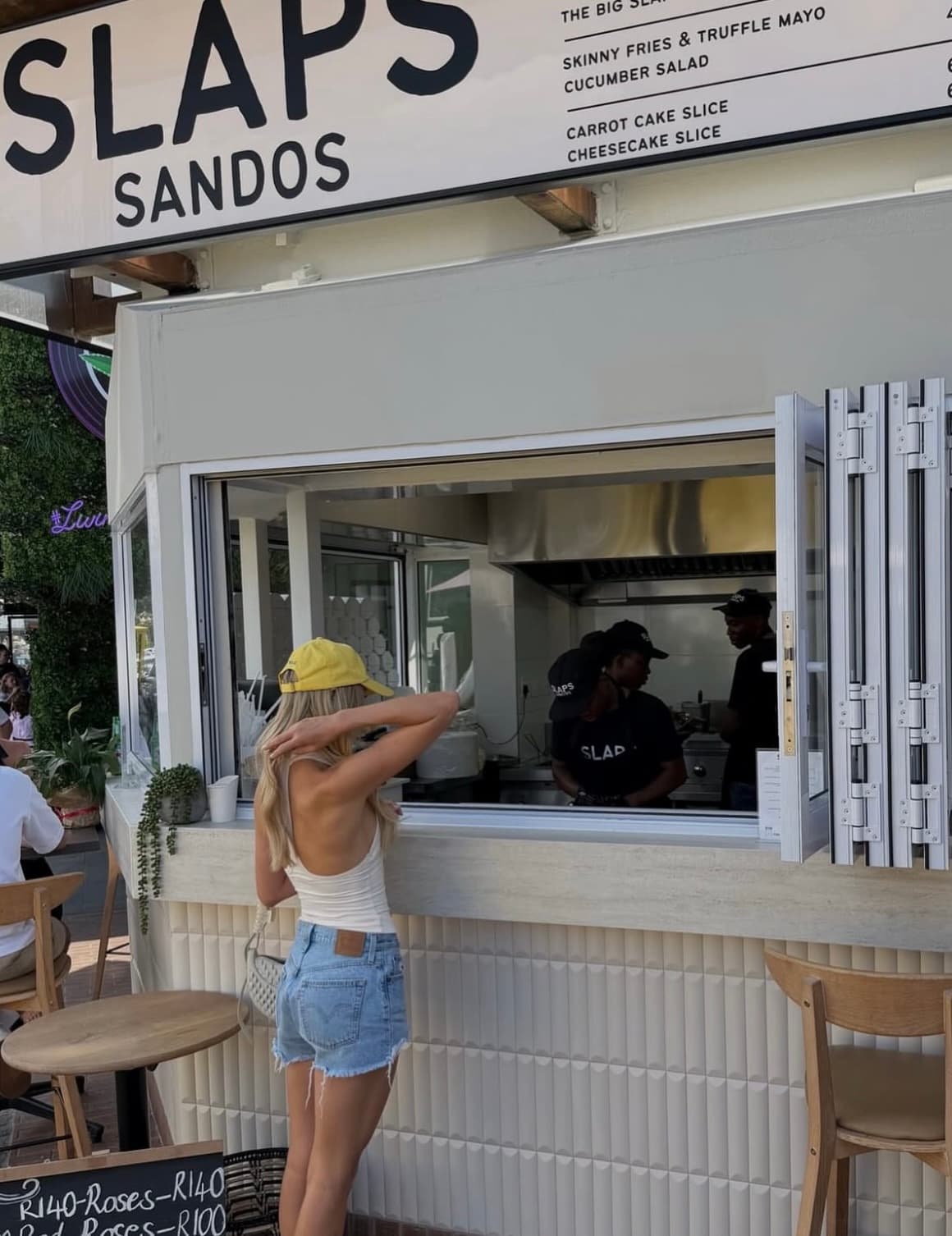 A customer ordering at the SLAPS Sandos takeaway window