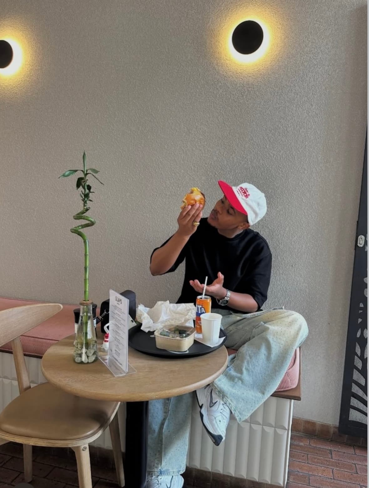A customer laughing while eating a SLAPS burger outdoors