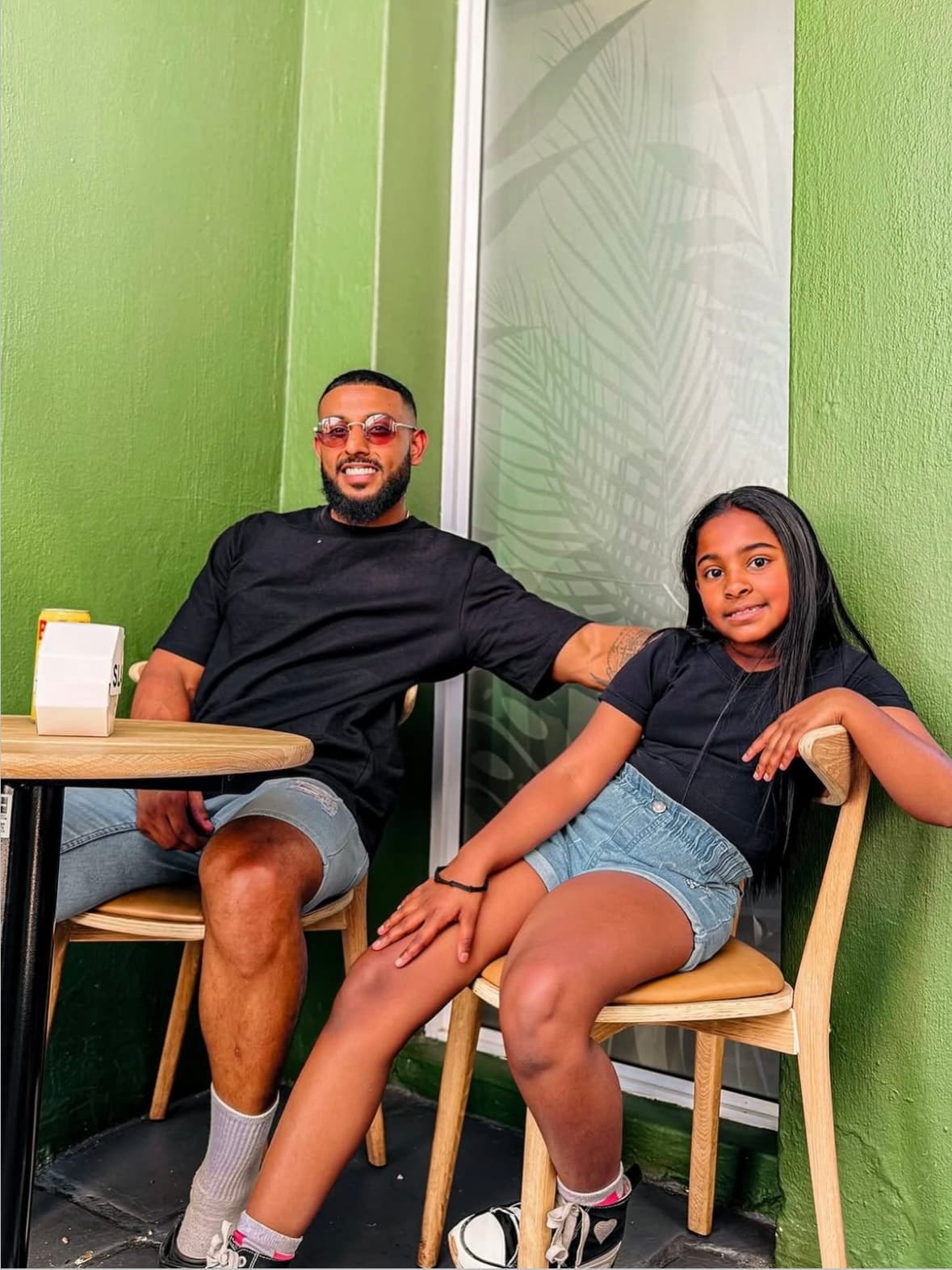 A dad and daughter sitting outside SLAPS Sandos